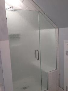 HG frameless door with inline notched panel, with clipped corner hinges, C-Pull, buried in tile